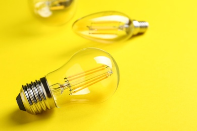 Vintage lamp bulb on yellow background. Space for text