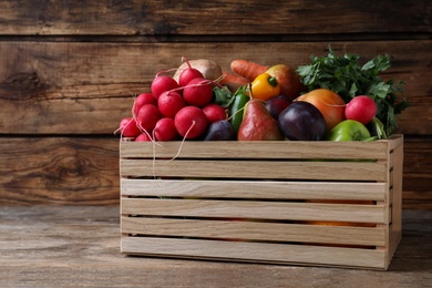 Crate full of different vegetables and fruits on wooden table. Harvesting time