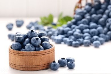 Tasty fresh blueberries on white table, closeup. Space for text
