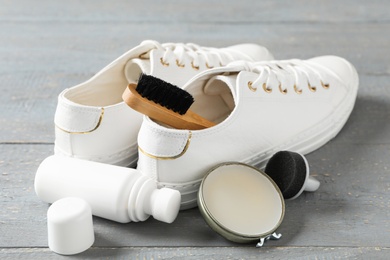 Composition with stylish footwear and shoe care accessories on grey wooden background