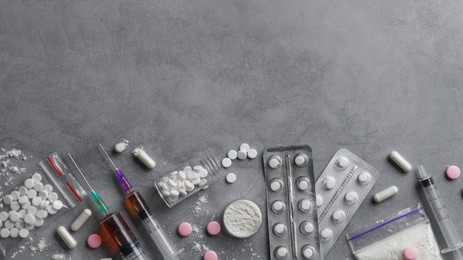Photo of Different hard drugs on grey table, flat lay. Space for text