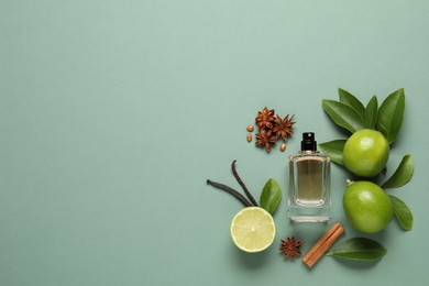 Flat lay composition with bottle of perfume and fresh citrus fruits on pale green background. space for text