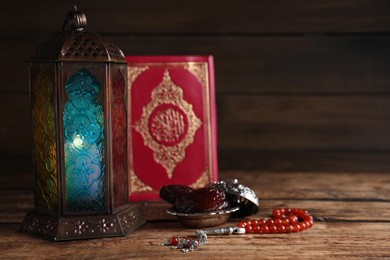 Composition with Arabic lantern and quran on wooden table. Space for text