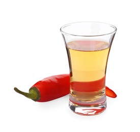 Red hot chili pepper and vodka in shot glass on white background