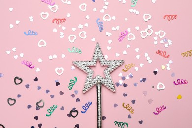Beautiful silver magic wand and confetti on pink background, flat lay