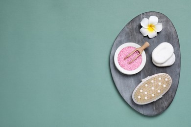 Board with spa items on pale green background, top view. Space for text