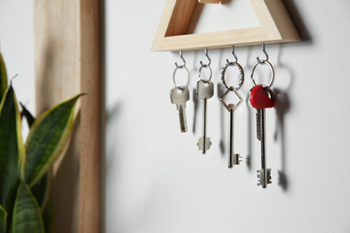 Wooden key holder on light wall indoors