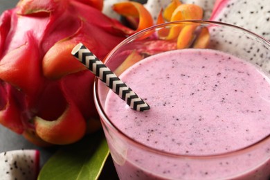 Delicious pitahaya smoothie and fresh fruits on table, closeup