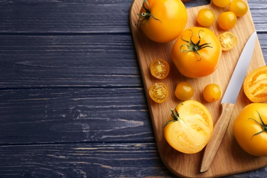 Ripe yellow tomatoes on blue wooden table, top view. Space for text