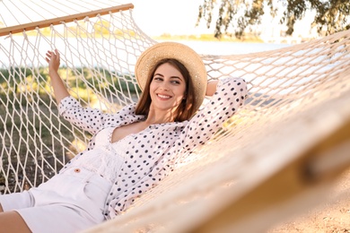 Young woman relaxing in hammock on beach. Summer vacation
