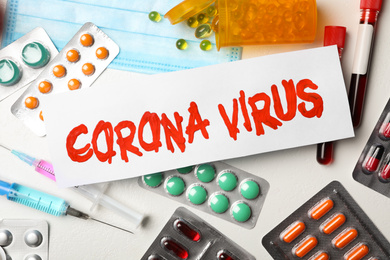 Flat lay composition with phrase CORONA VIRUS and medicines on white background