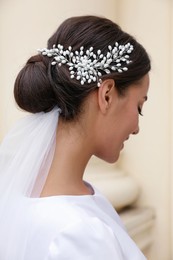 Young bride with elegant wedding hairstyle outdoors