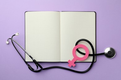 Female gender sign, open notebook and stethoscope on violet background, flat lay. Women's health concept