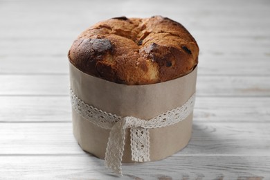 Photo of Delicious Panettone cake on white wooden table. Traditional Italian pastry