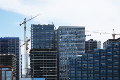 Photo of Construction site with tower cranes near unfinished buildings