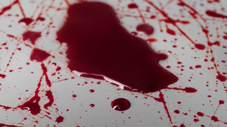 Stain and splashes of blood on light grey background, closeup