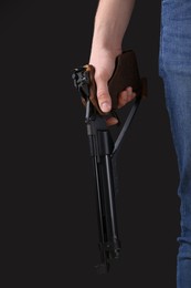 Gun shooting sport. Man holding standard pistol on dark background, closeup