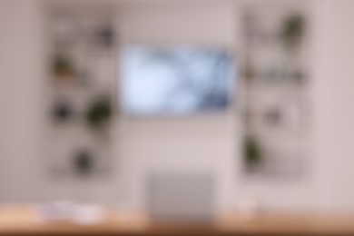 Photo of Interior design. Cosy workplace near tv area with shelves, blurred view