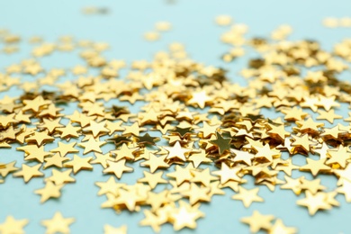 Confetti stars on light blue background, closeup. Christmas celebration