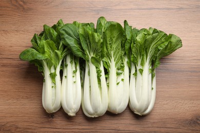 Fresh green pak choy cabbages on wooden table, flat lay