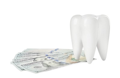 Ceramic model of tooth and dollar banknotes on white background. Expensive treatment