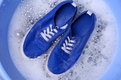 Washing sport shoes in plastic basin, top view