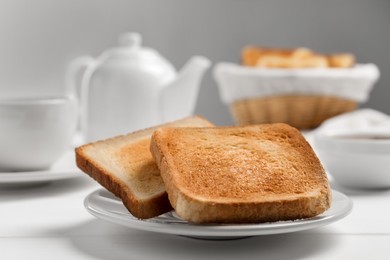 Photo of Slices of tasty toasted bread on white wooden table, closeup