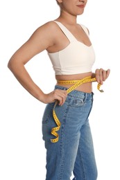 Woman measuring waist with tape on white background, closeup