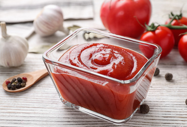Delicious tomato sauce on white wooden table, closeup