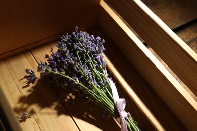 Photo of Beautiful fresh lavender bouquet in wooden crate, closeup