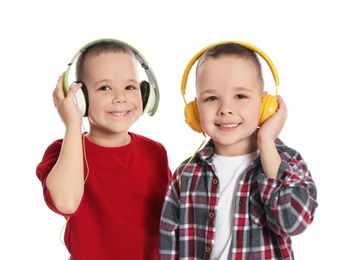 Portrait of cute twin brothers with headphones on white background