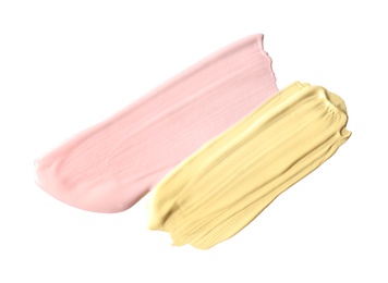Strokes of different color correcting concealers isolated on white