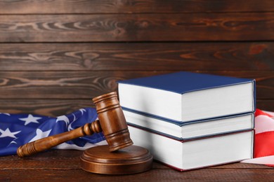 Judge's gavel, books and American flag on wooden table