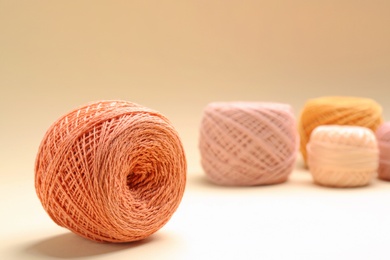 Clews of knitting threads on color background, space for text. Sewing stuff