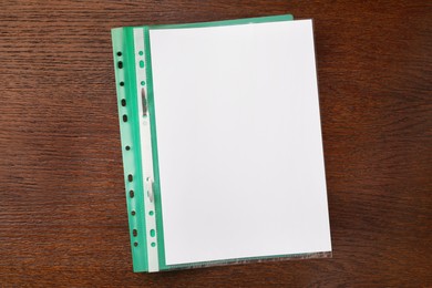 Photo of File folder with punched pocket on wooden table, top view. Space for text