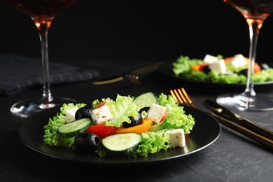 Tasty fresh Greek salad served on dark table