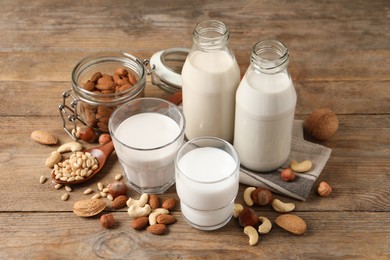 Different nut milks in glassware on wooden table