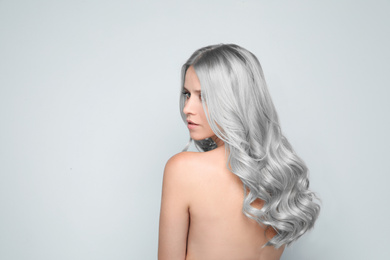 Woman with gray hair on light background