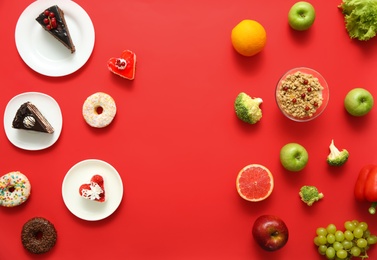 Photo of Choice concept. Flat lay composition with sweets and healthy food on red background