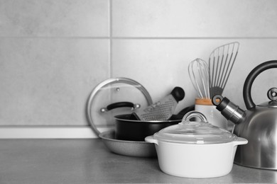 Cooking utensils and other kitchenware on grey countertop. Space for text