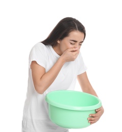 Young woman with basin suffering from nausea on white background. Food poisoning