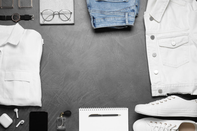 Stylish clothes and accessories on grey stone table, flat lay. Space for text