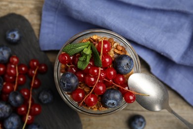Delicious yogurt parfait with fresh berries and mint on wooden table, flat lay