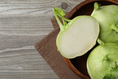 Whole and cut kohlrabi plants on wooden table, top view