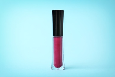 Beautiful lip gloss on color background