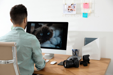 Photo of Professional photographer working at table in office