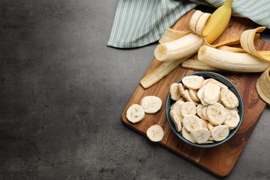 Photo of Freeze dried and fresh bananas on grey table, top view. Space for text