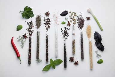 Flat lay composition with various spices, test tubes and fresh herbs on white background