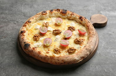 Photo of Delicious cheese pizza with walnuts and grapes on grey table