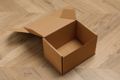 Photo of One empty open cardboard box on floor